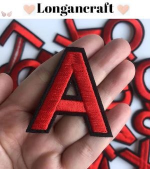 A hand holding a Red Iron On Letters