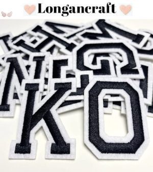 A pile of Black Embroidered Iron On Letters