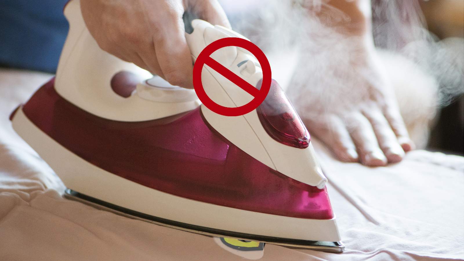 A person ironing a bed with a no steam sign.